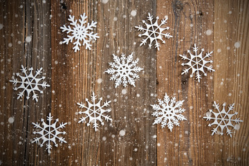Many Snowflakes on Brown Wooden Background. Snowy Vintage Or Grungy Background