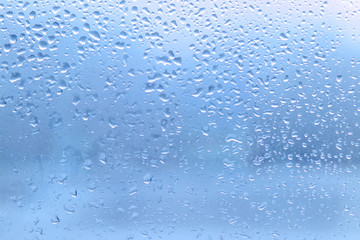 Rain drops on clean blue window glass