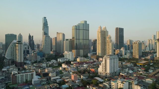bangkok city skyline with clear blue sky, aerial dolly left