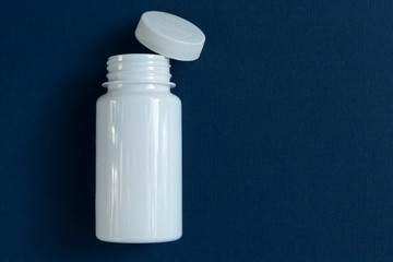 a white jar with a lid stands on a blue background