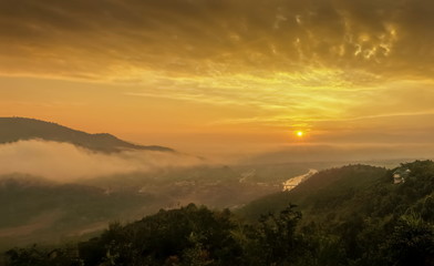 Naklejka na ściany i meble Mountain view misty morning above Kok river and Tha Ton city in valley around with sea of mist with cloudy sky background, sunrise at Wat Tha Ton, Fang, Chiang Mai, northern of Thailand.