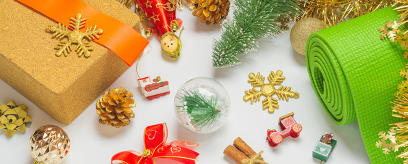 Green yoga mat or pilates mat with Christmas ornaments decoration for web banner. Christmas best...