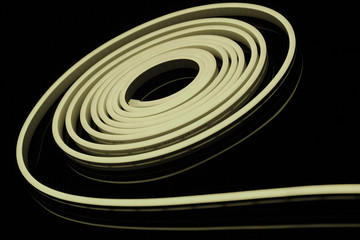 Warm white flexible led tape neon flex on black background.
