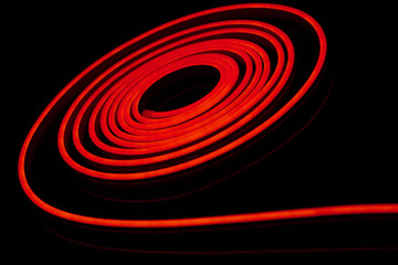 Red flexible led tape neon flex on black background.
