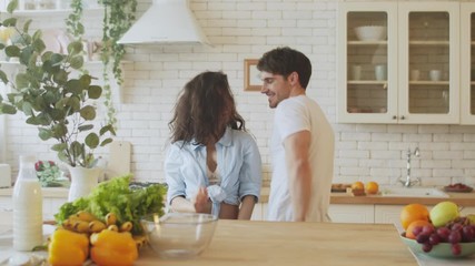 Happy couple dancing at kitchen in slow motion. Pretty woman in underwear.