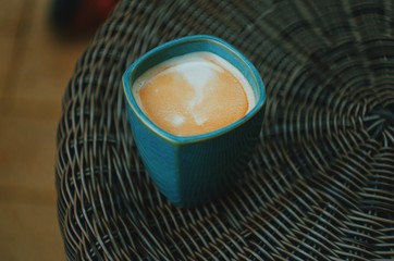 A blue cup of coffee without handle. Espresso closeup. Outdoor photography. Magical morning. Coffee with milk and foam. 100% Arabica. romantic breakfast