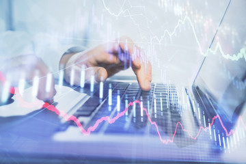 Double exposure of market chart with man working on computer on background. Concept of financial analysis.