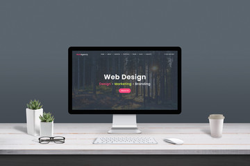 Web design studio concept. Work desk with computer display and modern design web agency page. - obrazy, fototapety, plakaty