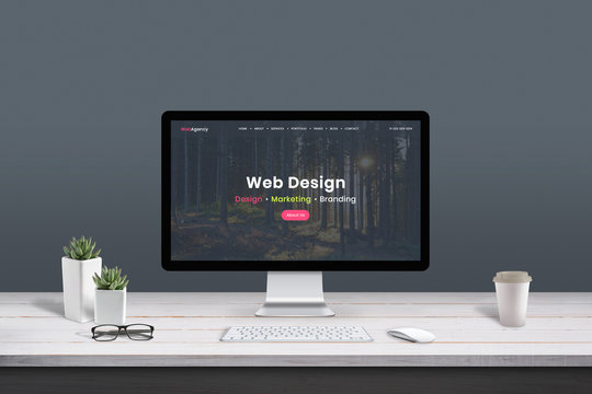Web design studio concept. Work desk with computer display and modern design web agency page.