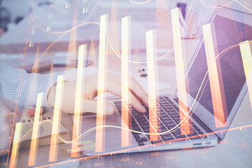Fototapeta premium Multi exposure of stock market graph with man working on laptop on background. Concept of financial analysis.