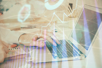 Double exposure of stock market graph with man working on laptop on background. Concept of financial analysis.