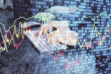 Stock graph with businessman typing on computer in office on background. Concept of analysis. Double exposure.