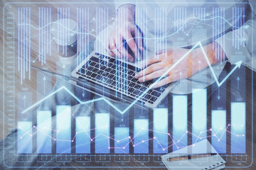 Forex graph with businessman working on computer in office on background. Concept of analysis. Double exposure.