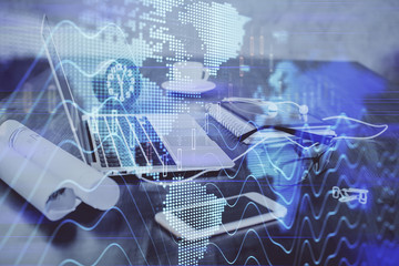 Stock market graph on background with desk and personal computer. Double exposure. Concept of financial analysis.