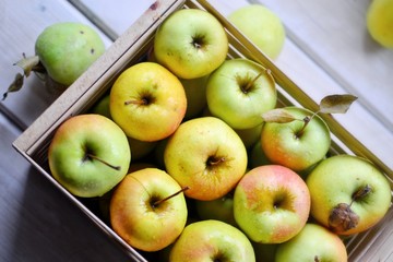 Juicy ripe apples. Yellow-green apples in a wooden box