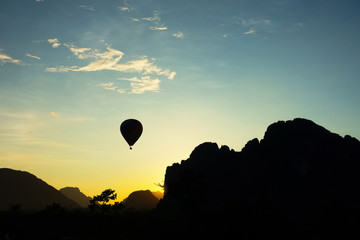 The view in the natural park called Vang Vieng in Laos with ballon and mountains with sky at the background , silhouette style. 