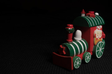 Fototapeta na wymiar Red children`s Christmas train on a black background. New Year's toy.