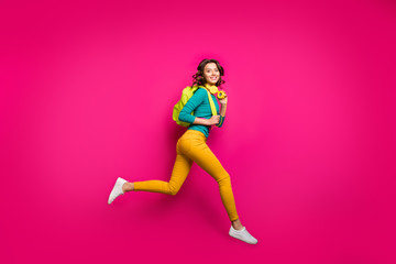 Fototapeta na wymiar Full length body size side profile photo of cheerful casual cute curly wavy pretty girlfriend wearing white sneakers yellow pants trousers smiling toothily isolated fuchsia vibrant color background