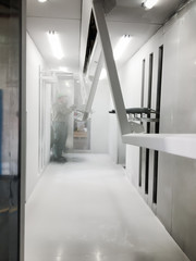 Powder coating line. Metal panels are suspended on an overhead conveyor line. Painting products in...