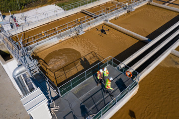 Engineers assesing waste treatment plant with drone