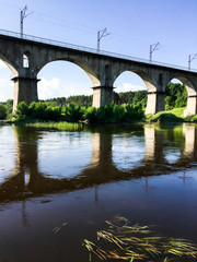 Fototapeta premium Stone bridge across the river on a sunny day
