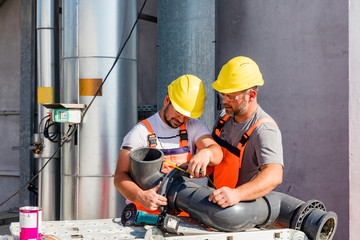 Workers assembling PVC piping