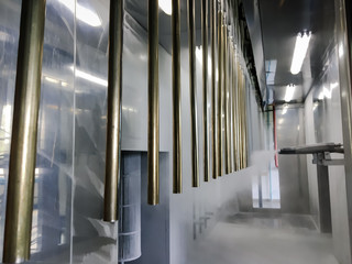 Obraz premium Industrial conveyor line at the factory for metal parts. Pretreatment of the surface of parts and paint parts with powder paint.