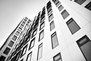 Modern European building. White building with many windows against the blue sky. Abstract architecture, fragment of modern urban geometry. Black and white.