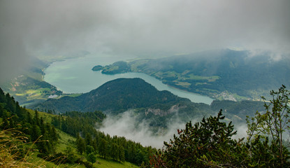 view of mountains through clouds in valley with wolfgangsee