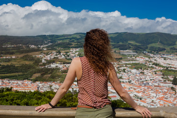 Naklejka na ściany i meble A young woman is standing in front of Angra do Heroismo, Terceira, Azores, Portugal.