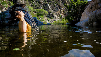 Fototapeta na wymiar Women splashing hair in water at deep creek hot springs