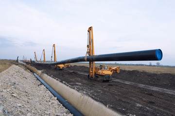 Pipeline construction for natural gas. Heavy duty construction machines carrying and placing gas...
