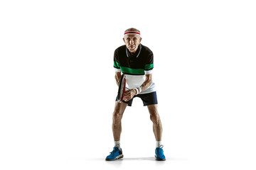Senior man wearing sportwear playing tennis isolated on white background. Caucasian male model in great shape stays active and sportive. Concept of sport, activity, movement, wellbeing. Copyspace, ad.