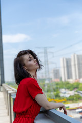 girl in a red dress on the roof overlooking the city