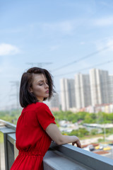 girl in a red dress on the roof overlooking the city