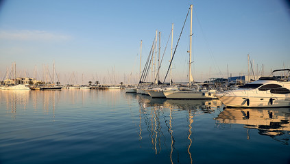 yachts in the dock at sunset with reflection in the water. Mediterranean sea.