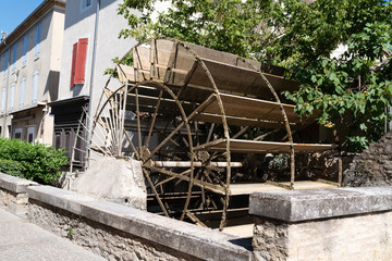 Fototapeta na wymiar water mill wheel on city canal L'Isle-sur-la-Sorgue Vaucluse France