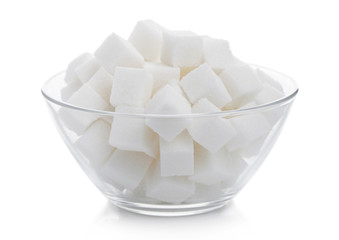 Glass bowl of natural white sugar cubes on white background.