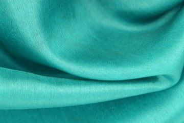 Green silk is draped with soft folds, background