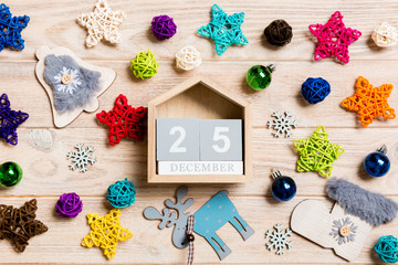 Top view of calendar on Christmas wooden background. The twenty fifth of December. New Year toys and decorations. Holiday concept