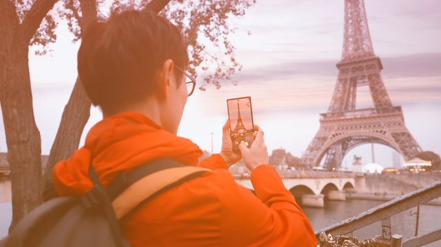 Travel tourist  which  he's a take a picture by smartphone at Eiffel tower, Paris. France