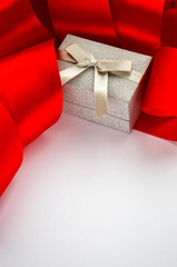 Gift box with red ribbon on the white background. Christmas sale of jewelry. Discounts for Saint Valentines Day. Banner template with copy space for text. Selective focus