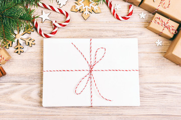 Parcel in Envelope with Fir-tree Branches and christmas decoration on a Wooden Background. Toned