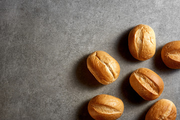 Freshly baked little buns on a gray stone surface. Top view.