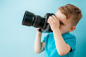 Little boy with camera on a blue background