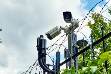 CCTV camera and motion detectors on the fance with barded wire. Private territory and secret...
