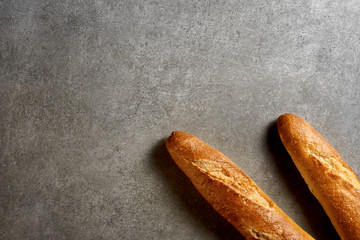 Fresh french baguettes on a gray stone surface. Top view.