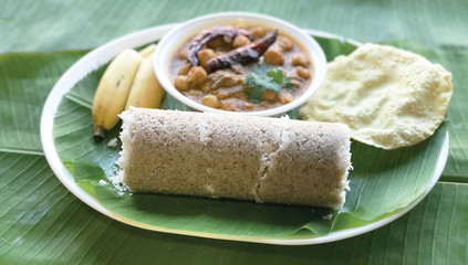 Popular South Indian breakfast Puttu or Pittu made of steamed rice flour and grated coconut in the bamboo mould with banana Kerala, India. Sri lankan food - Image
