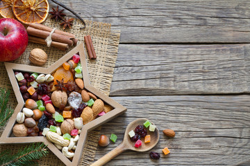 Nuts and dried fruits mix for Christmas on wooden boards background