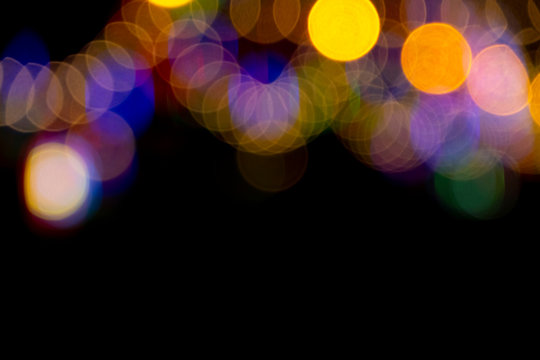 Defocused of photo bokeh blurred circle light from colorful neon lighting bulb in the night for abstract background texture pattern